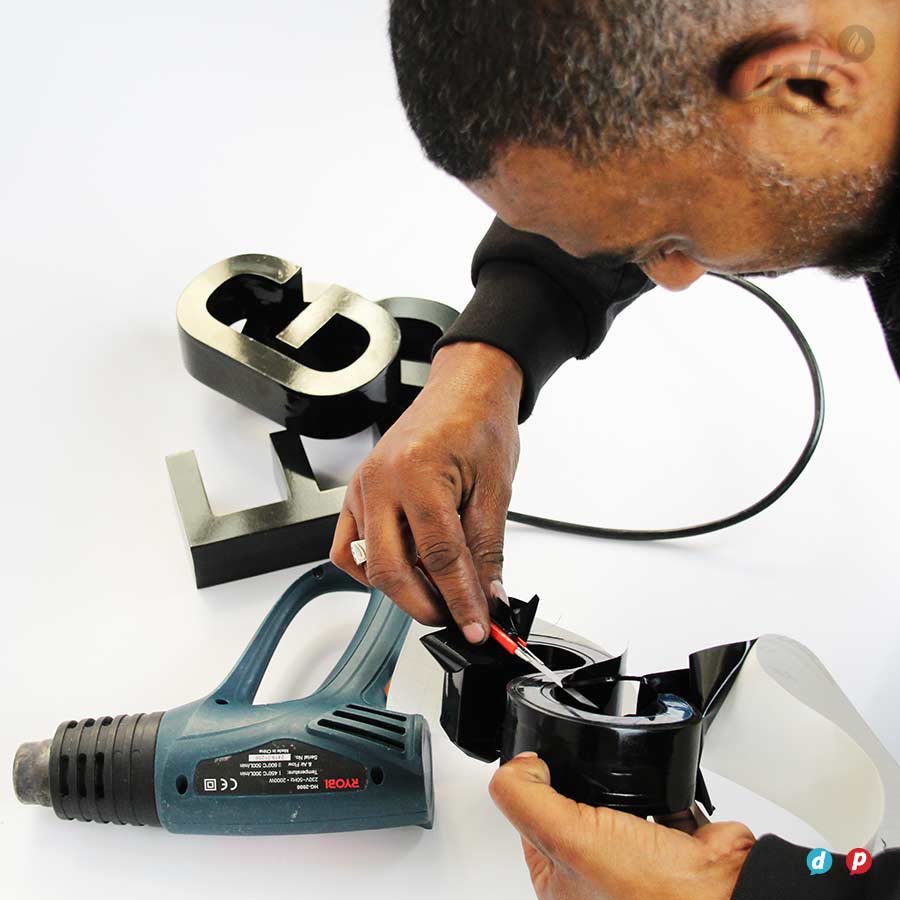 man making-3D-Letters-for-signage using a heat gun