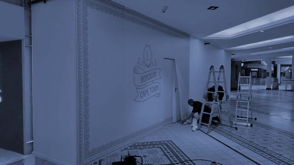 man applying wallpaper in a mall