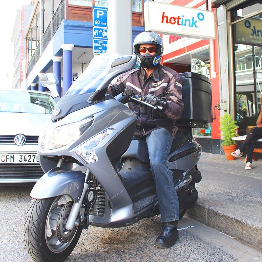 Hot Ink delivery rider on a scooter outside the store in South Africa.