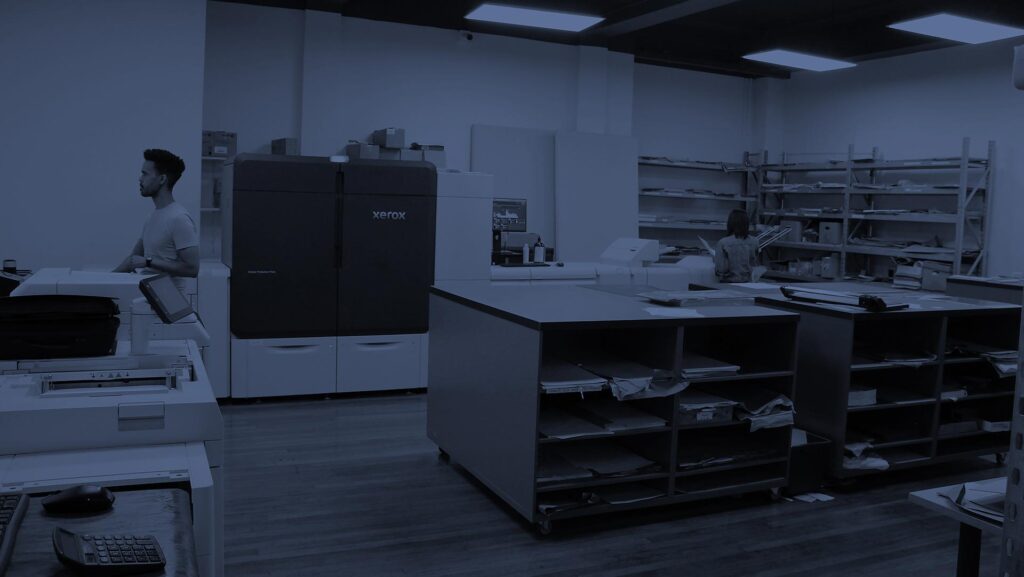 Hot Ink printing machine in a modern print shop with staff working on printing tasks.